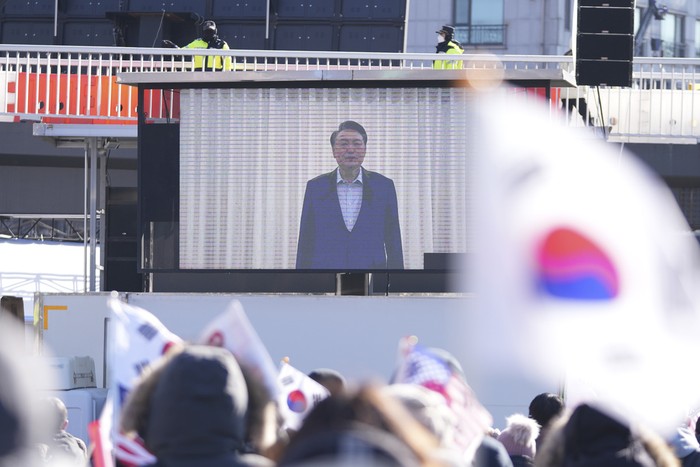 Police officers walk to the gate of the presidential residence in Seoul, South Korea, Wednesday, Jan. 15, 2025. (AP Photo/Lee Jin-man)