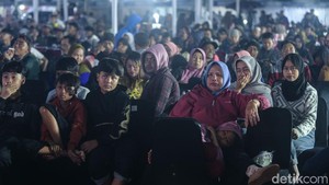Cuaca yang dingin membuat mereka mengenakan jaket hingga sarung saat menonton wayang. 