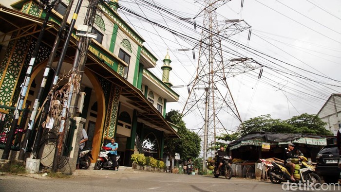 Bangunan seperti rumah hingga masjid berdiri dekat dengan SUTET di Kecamatan Bojongsari, Depok, Jawa Barat, Rabu (15/1/2025). Mendirikan bangunan di bawah SUTET sangat tidak dianjurkan karena berbahaya dan dapat menimbulkan gangguan kesehatan.