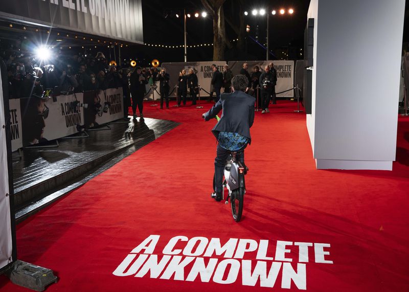 Timothee Chalamet rides an electronic bicycle upon arrival at the premiere of the film 'A Complete Unknown' in London, on Tuesday, Jan. 14, 2025. (Photo by Scott A Garfitt/Invision/AP)
