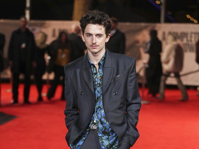 Timothee Chalamet rides an electronic bicycle upon arrival at the premiere of the film A Complete Unknown in London, on Tuesday, Jan. 14, 2025. (Photo by Scott A Garfitt/Invision/AP)