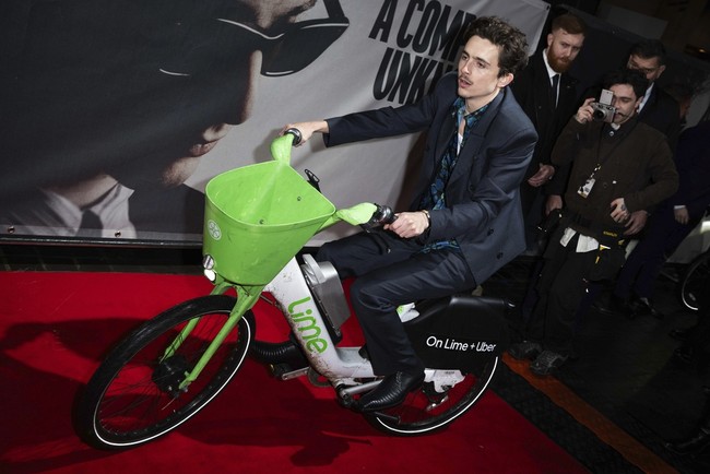 Aktor Timothée Chalamet kembali mencuri perhatian di acara karpet merah. Kali ini, ia membuat kejutan dengan tiba di premiere film A Complete Unknown di London menggunakan sepeda listrik berwarna cerah alih-alih mobil limosin yang biasanya digunakan para bintang Hollywood. (Foto: Scott Garfitt/Invision/AP)