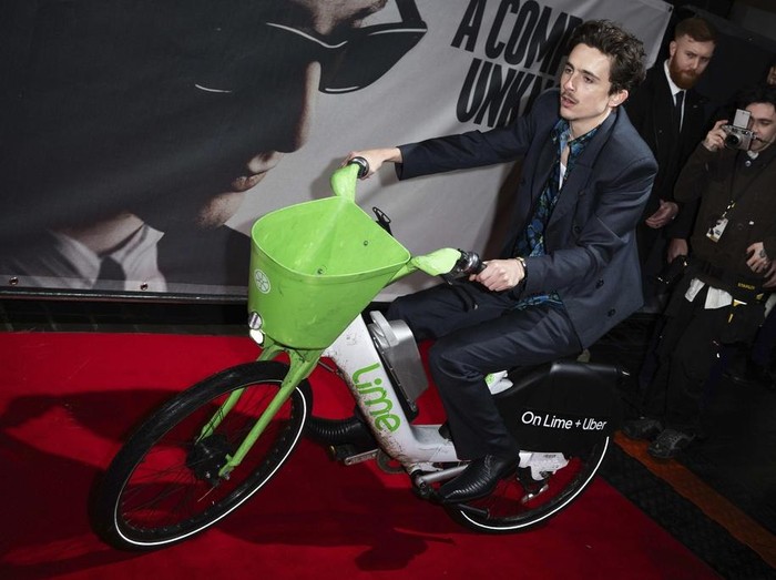 Timothee Chalamet di Karpet Merah Premier A Complete Unknown Timothee Chalamet rides an electronic bicycle upon arrival at the premiere of the film A Complete Unknown in London, on Tuesday, Jan. 14, 2025. (Photo by Scott A Garfitt/Invision/AP)