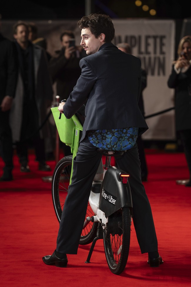 Kehadirannya dengan sepeda listrik yang sedikit berlumpur, di tengah-tengah rekan-rekannya yang tampil glamor, menciptakan pemandangan unik dan mengundang senyum. Kendati demikian, Chalamet tetap bersolek necis dengan setelan dari label fashion London, Martine Rose. (Foto: Scott Garfitt/Invision/AP)