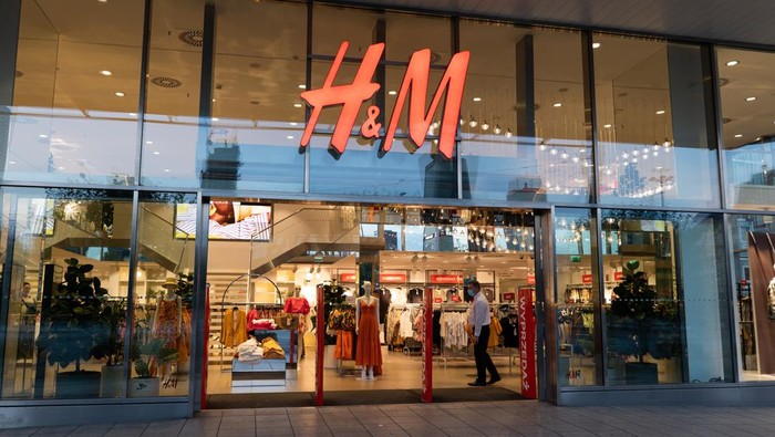 Warsaw, Poland - June 18, 2020: Entrance to H&M store, clothing retail company in the city center at night