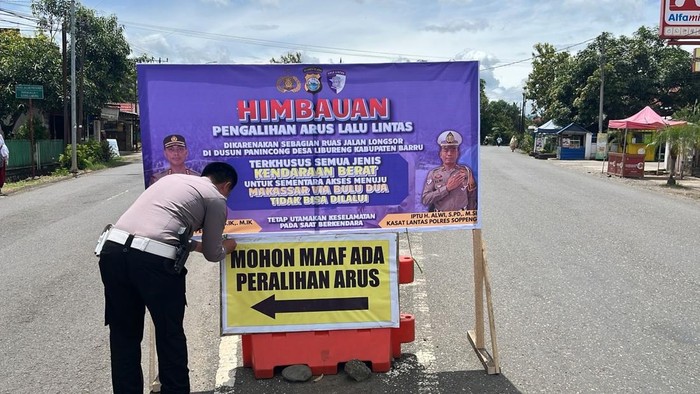 Polisi memasang pemberitahuan untuk tidak lewat Jalan Poros Bulu Dua- Pekka, Barru.