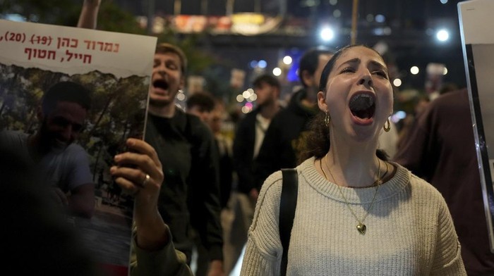 Relatives and friends of people killed and abducted by Hamas and taken into Gaza, react to the ceasefire announcement as they take part in a demonstration in Tel Aviv, Israel, Wednesday, Jan. 15, 2025. (AP Photo/Ohad Zwigenberg)