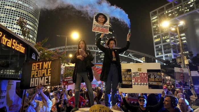 Hamas Akan Bebaskan Sandera, Warga Israel Sorak Gembira Relatives and friends of people killed and abducted by Hamas and taken into Gaza, react to the ceasefire announcement as they take part in a demonstration in Tel Aviv, Israel, Wednesday, Jan. 15, 2025. (AP Photo/Ohad Zwigenberg)