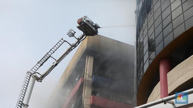 Kebakaran besar yang melanda Glodok Plaza, Jakarta Barat yang terjadi pada Rabu (15/1) malam masih berlangsung hingga pagi ini. Para petugas damkar berjibaku memadamkan api. (CNBC Indonesia/Tri Susilo)