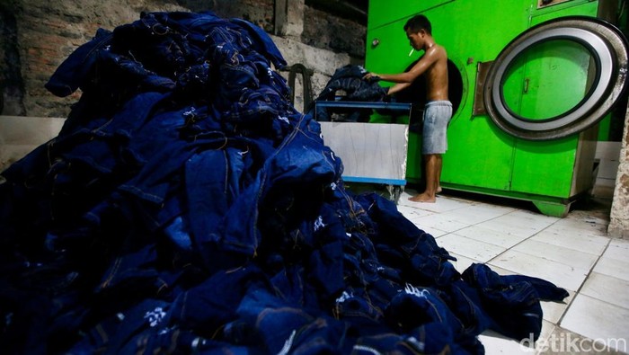 Pekerja menyelsaikan pembuatan celana jins disalah satu industri rumaha di Jakarta, Kamis (15/1/2025). Dalam sehari industri konveksi celana jins tersebut mampu menyelesaikan sekitar 4.000 sampai 5.000 celana yang akan dijual ke berbagai daerah di Pulau Jawa, Sumatera dan Kalimantan.