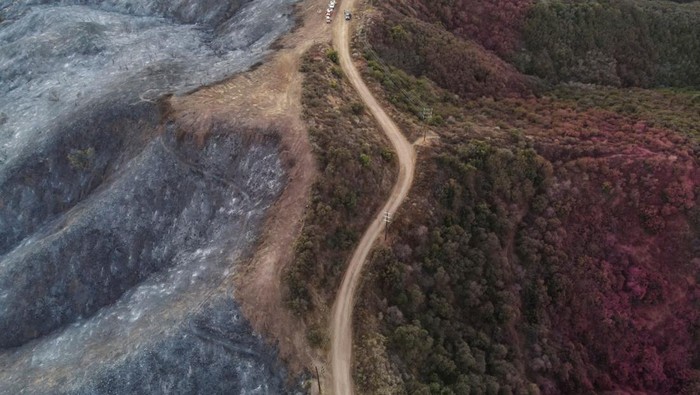 A drone view shows a CalFire crew mopping up hotspots from the burn scar of the Palisades Fire near Mulholland Drive in Los Angeles, California, U.S., January 15, 2025. REUTERS/David Swanson