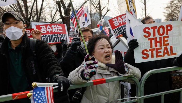 Potret Pendukung Yoon Suk Yeol Unjuk Rasa di Luar Pusat Penahanan A Pro-Yoon supporter shouts during a live broadcast by a local news channel, expressing her stance on the mediaβs coverage during a rally outside the Seoul Detention Center in Uiwang, where impeached South Korean President Yoon Suk Yeol is held in custody, in Uiwang, South Korea, January 16, 2025. REUTERS/Tyrone Siu