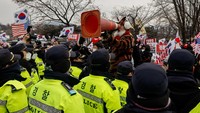 Sementara itu, pendukung Yoon melambaikan spanduk dan meneriakkan yel-yel selama protes di luar Pusat Penahanan Seoul. REUTERS/Tyrone Siu  