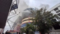 Petugas pemadam kebakaran masih berupaya memadamkan api di area sekeliling Glodok Plaza. Terlihat asap hitam mengepul keluar dari jendela, dan kaca di lantai atas pecah. (Foto: Maulani Mulianingsih/detikcom)