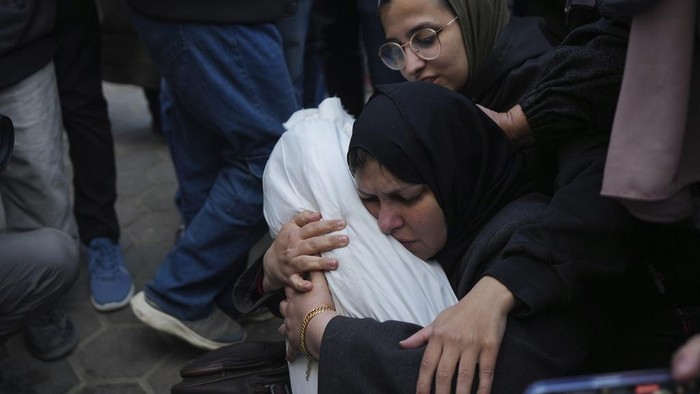 Hanan Shaqoura embraces the body of her son, Mohammad, 7, who was killed in the Israeli bombardment of the Gaza Strip, during his funeral in Deir al-Balah, Wednesday, Jan. 15, 2025. (AP Photo/Abdel Kareem Hana)