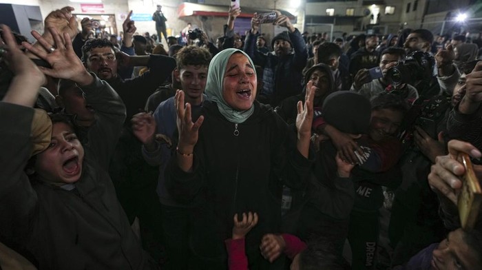Palestinians celebrate the announcement of a ceasefire deal between Hamas and Israel in Deir al-Balah, central Gaza Strip, Wednesday, Jan. 15, 2025. (AP Photo/Abdel Kareem Hana)
