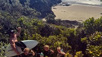 Chrismebmagiakn keseruan weekendnya bersama anak-anaknya dnegan surfing. Beginilah momen mereka menuruni tebing meuju pantai.