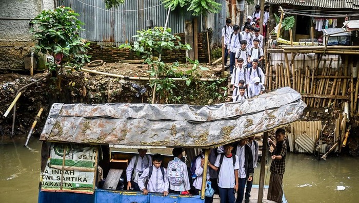 Sejumlah pelajar antre untuk menaiki perahu eretan di Kali Pesanggrahan, Jakarta, Jumat (17/1/2025). Jasa penyeberangan eretan sebesar Rp2.000 tersebut mayoritas digunakan para pelajar sebagai alternatif transportasi untuk mempersingkat waktu dan jarak tempuh dari Tanah Kusir menuju Pesanggrahan atau sebaliknya. ANTARA FOTO/Rivan Awal Lingga/Spt.