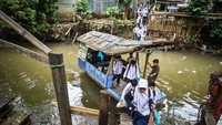 Sejumlah pelajar menaiki perahu eretan untuk menyeberangi Kali Pesanggrahan, Jakarta, Jumat (17/1/2025). 