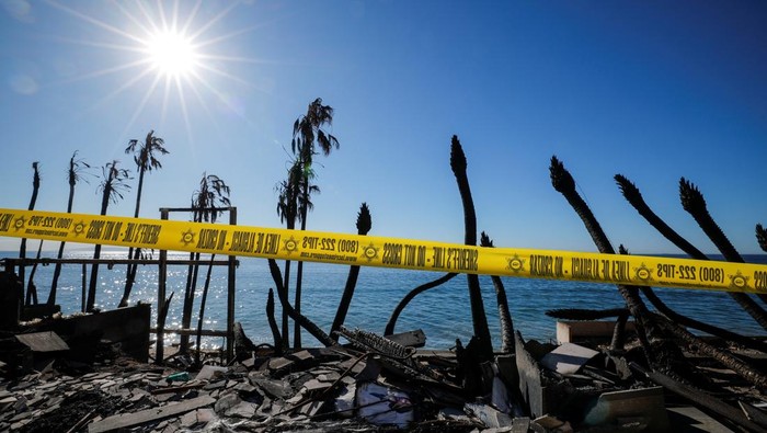 Firefighters walk next to the remains of beachfront houses that burnt down in the Palisades Fire, in Malibu, California, U.S., January 16, 2025. REUTERS/Mike Blake     TPX IMAGES OF THE DAY