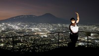 Seorang wanita membuat video dengan pemandangan kota San Salvador dari titik pengamatan pertanian San Antonio Amatepec, di Soyapango, El Salvador, Kamis (16/1/2025).  