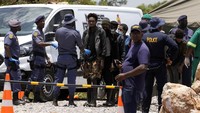 Para penambang dikawal oleh petugas polisi setelah diselamatkan dari bawah tanah di tambang emas yang terbengkalai selama berbulan-bulan, di Stilfontein, Afrika Selatan.