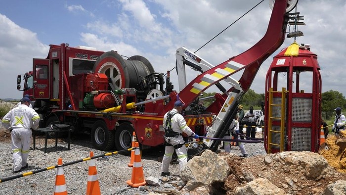 Mine rescue workers host up a cage that was used to rescue trapped miners at an abandoned gold mine, where miners were rescued from below ground, in Stilfontein, South Africa, Thursday, Jan. 16, 2025. (AP Photo/Themba Hadebe)