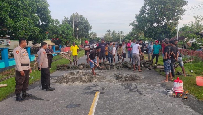Keluarga korban memblokade jalan dengan membuat pondasi dari semen di jalan Desa Tomalehu, Kecamatan Amalatu pada Jumat (17/1).