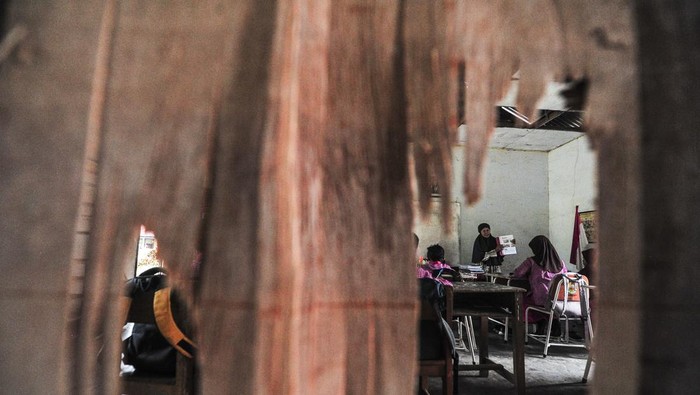 Guru memeberi materi pelajaran kepada siswa kelas IV di ruang perpustakaan yang dijadikan kelas di SDN 109 Desa Ladang Panjang, Muaro Jambi, Jambi, Jumat (17/1/2025). SD tertua di Desa Ladang Panjang, dibangun tahun 1983 itu memiliki keterbatasan ruang kelas sehingga terpaksa memanfaatkan ruang perpustakaan yang rusak untuk kegiatan belajar mengajar selama hampir 20 tahun. ANTARA FOTO/Wahdi Septiawan/Spt.