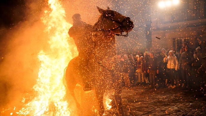 A man rides a horse through flames during the annual 