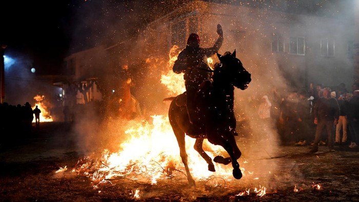 Aksi Mendebarkan Menunggang Kuda Lompati Api dalam Festival Las Luminarias A man rides a horse through flames during the annual