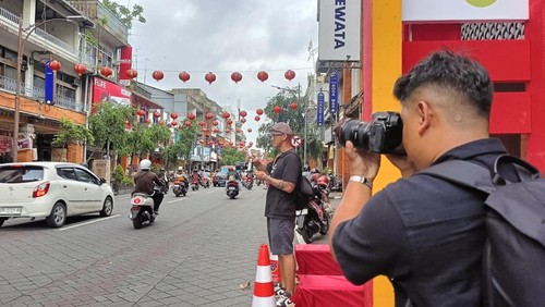 Anggota Komunitas Kelas Pagi Indonesia memotret lampion di kawasan Jalan Gajah Mada, Denpasar, Bali, Sabtu (18/1/2025). (Karsiani Putri/detikBali)