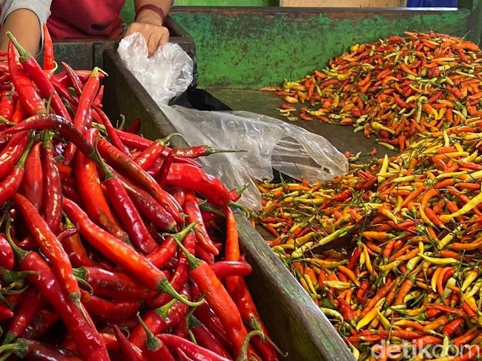 Pedagang menunjukkan Cabai yang Harganya Masih Pedas