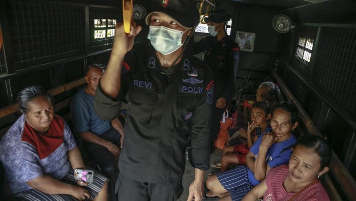Personel Polri membantu warga turun dari truk Korps Brimob Polda Malut setibanya di lokasi pengungsian di Desa Ake Sibu,Kabupaten Halmahera Barat, Maluku Utara, Sabtu(18/1/2025). Setelah dilakukan sosialisasi dan edukasi kepada masyarakat yang berada di zona merah rawan bencana erupsi Gunung Ibu itersebut akhirnya mereka dievakuasi oleh Korps Brimob Polda Malut, Kodim 1501/Ternate ke tempat pengungsian di SD Inpres 18 Halmahera Barat. ANTARA FOTO/Andri Saputra/YU