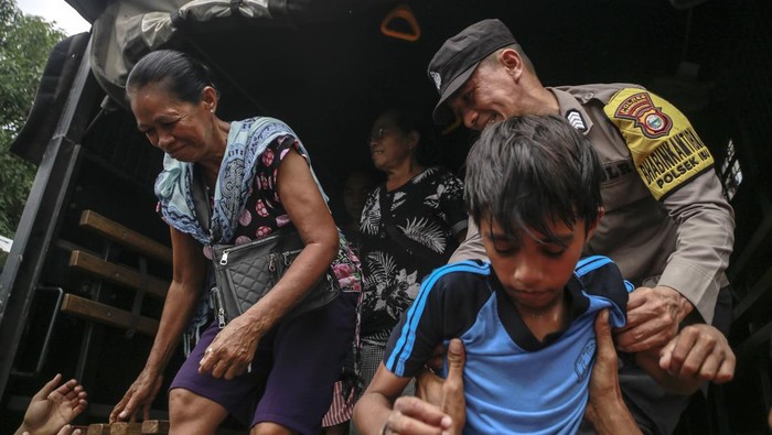 Personel Polri membantu warga turun dari truk Korps Brimob Polda Malut setibanya di lokasi pengungsian di Desa Ake Sibu,Kabupaten Halmahera Barat, Maluku Utara, Sabtu(18/1/2025). Setelah dilakukan sosialisasi dan edukasi kepada masyarakat yang berada di zona merah rawan bencana erupsi Gunung Ibu itersebut akhirnya mereka dievakuasi oleh Korps Brimob Polda Malut, Kodim 1501/Ternate ke tempat pengungsian di SD Inpres 18 Halmahera Barat. ANTARA FOTO/Andri Saputra/YU