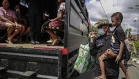 Personel Brimob menggendong seorang anak yang terdampak erupsi Gunung Ibu naik ke atas truk Korps Brimob Polda Malut menuju lokasi pengungsian saat dievakuasi di Desa Togoreba Sungi, Kabupaten Halmahera Barat, Maluku Utara, Sabtu(18/1/2025).
