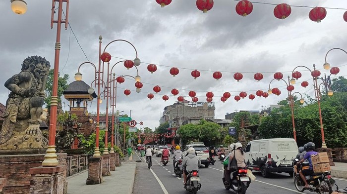 Pengendara melintas di Jalan Gajah Mada, Denpasar, yang dihiasi lampion merah, Sabtu (18/1/2025). Lampion dipasang menjelang perayaan Imlek 2025 (Karsiani Putri/detikBali).