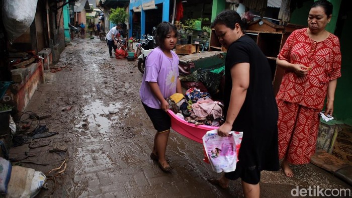 Warga Bandar Lampung saat membesihkan rumahnya usai kebanjiran