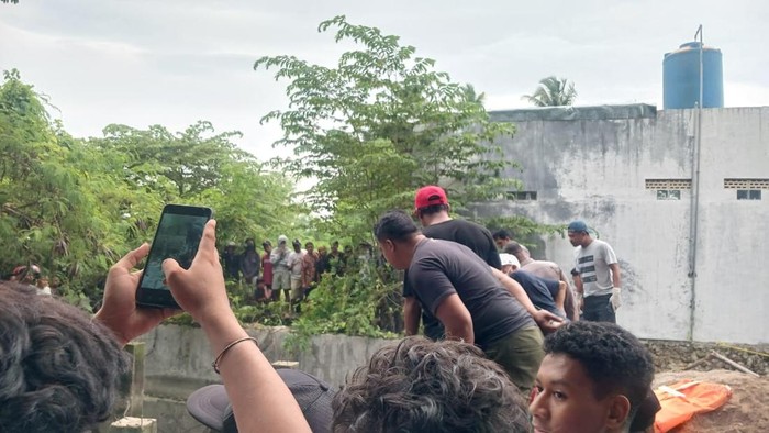Warga memadati bak bekas penampungan air, lokasi penemuan mayat pria tanpa identitas, di RT 35, RW 09, Kelurahan Oebufu, Kecamatan Oebobo, Kota Kupang, Nusa Tenggara Timur (NTT), Sabtu (18/1/2025). (Yufengki Bria/detikBali)
