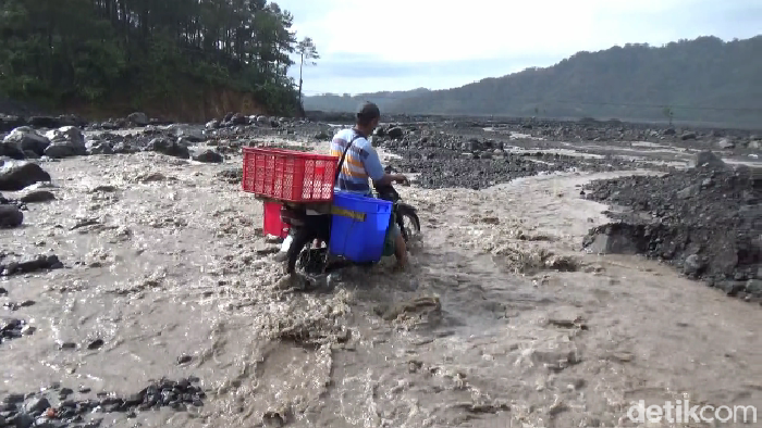 warga nekat melintas saat banjir lahar dingin untuk beraktifitas sehari-hari