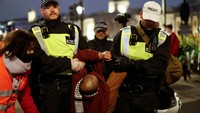 Polisi menggotong salah satu demonstran.