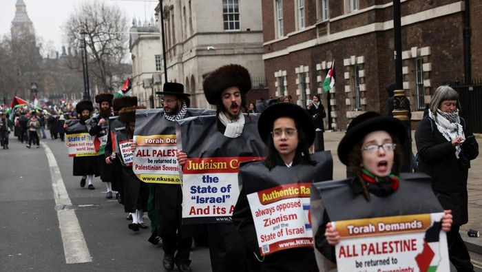 70 Orang Ditangkap saat Aksi Pro-Palestina di London Ultra-Orthodox Jews hold placards at a demonstration in support of Palestinians in Gaza, after Israel and Hamas reached a ceasefire deal, in London, Britain January 18, 2025. REUTERS/Carlos Jasso