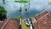 Foto udara perahu bersandar di akses jalan yang tertutup banjir di Desa Kedungringin, Beji, Pasuruan, Jawa Timur, Minggu (19/1/2025). 