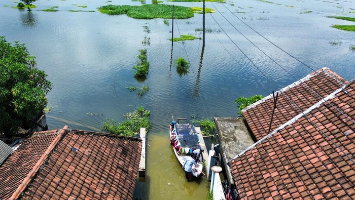 Banjir di Beji Pasuruan Warga menggunakan perahu untuk kembali ke rumahnya yang terendam banjir di Desa Kedungringin, Beji, Pasuruan, Jawa Timur, Minggu (19/1/2025). Hujan yang turun dengan intensitas cukup tinggi beberapa hari terakhir merendam sekitar 2.350 rumah di enam desa kecamatan beji, Pasuruan dengan ketinggian 40-60 cm sehingga menyebabkan aktivitas masyarakat terganggu. ANTARA FOTO/Umarul Faruq/nz