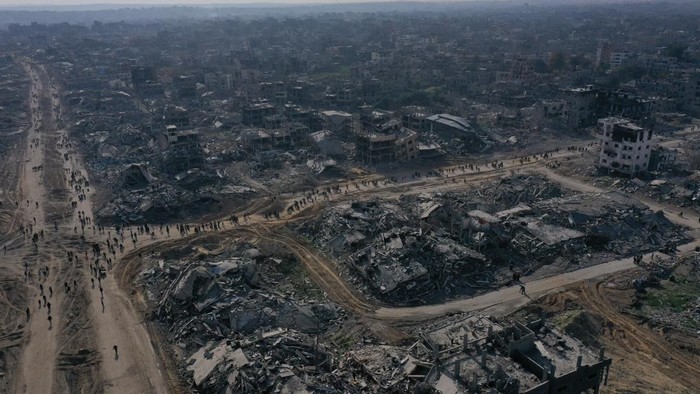 A drone view shows displaced Palestinians walking past the rubble as they attempt to return to their homes, amid a ceasefire between Israel and Hamas, in the northern Gaza Strip, January 19, 2025. REUTERS/Mahmoud Al-Basos