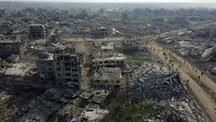 A drone view shows displaced Palestinians walking past the rubble as they attempt to return to their homes, amid a ceasefire between Israel and Hamas, in the northern Gaza Strip, January 19, 2025. REUTERS/Mahmoud Al-Basos