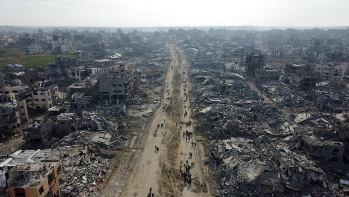 A drone view shows displaced Palestinians walking past the rubble as they attempt to return to their homes, amid a ceasefire between Israel and Hamas, in the northern Gaza Strip, January 19, 2025. REUTERS/Mahmoud Al-Basos