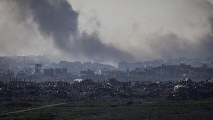 This picture taken from the Israeli side of the border with the Gaza Strip shows smoke plumes rising from explosions above destroyed buildings in the northern Gaza Strip on January 18, 2025, a day before a ceasefire is set to take effect following the Israeli cabinets approval of a deal between Israel and Hamas. The ceasefire in the Gaza war will begin at 0630 GMT on January 19, mediator Qatar said after Israels cabinet voted to approve the truce and hostage-prisoner release deal. In more than 15 months of war between Hamas Palestinian militants and Israel, there has been only one previous truce, for one week, in November 2023 that also saw a hostage-prisoner exchange. (Photo by JOHN WESSELS / AFP)