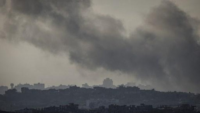 This picture taken from the Israeli side of the border with the Gaza Strip shows smoke plumes rising from explosions above destroyed buildings in the northern Gaza Strip on January 18, 2025, a day before a ceasefire is set to take effect following the Israeli cabinets approval of a deal between Israel and Hamas. The ceasefire in the Gaza war will begin at 0630 GMT on January 19, mediator Qatar said after Israels cabinet voted to approve the truce and hostage-prisoner release deal. In more than 15 months of war between Hamas Palestinian militants and Israel, there has been only one previous truce, for one week, in November 2023 that also saw a hostage-prisoner exchange. (Photo by JOHN WESSELS / AFP)