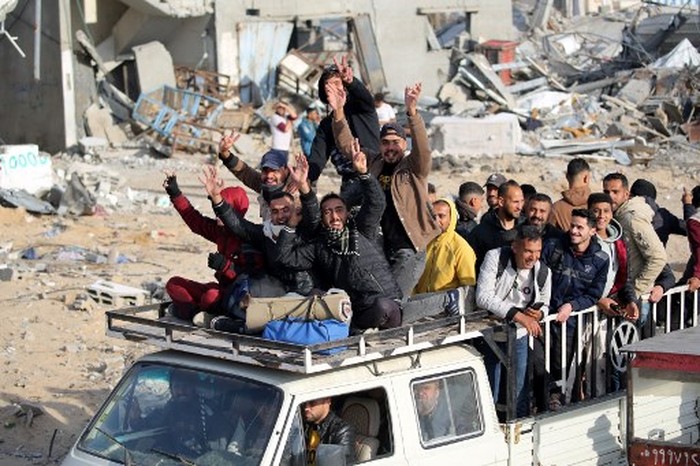 Displaced Palestinians cheer as they return to Rafah in the southern Gaza Strip on January 19, 2025, hours after a ceasefire deal in the war between Israel and the Palestinian militant group Hamas was expected to be implemented. (Photo by Eyad BABA / AFP)
